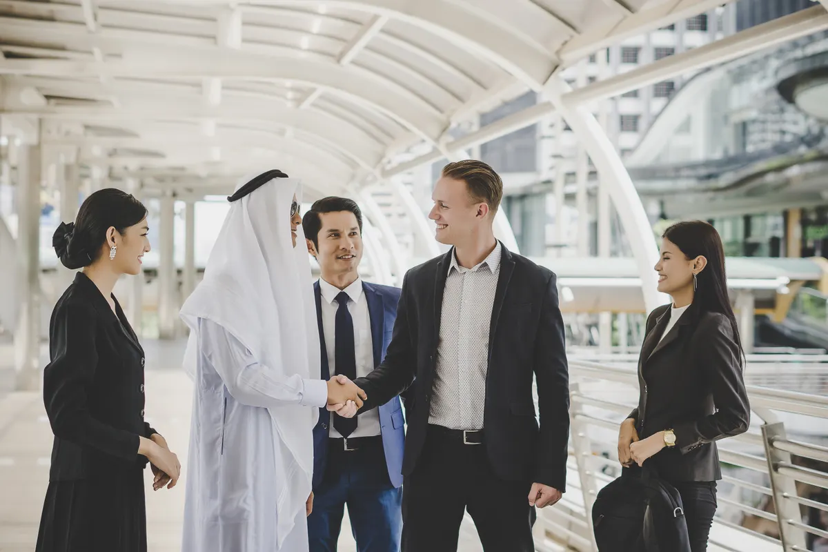 Business people shaking hands outside an office building